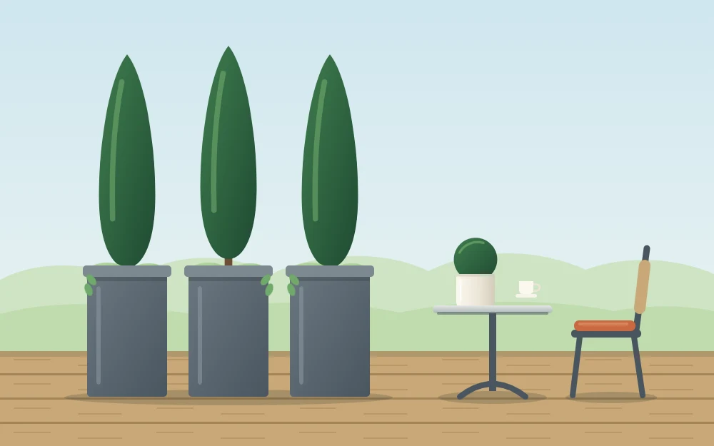 A row of three tall narrow planters with upright evergreen plants forming a green screen beside a small table